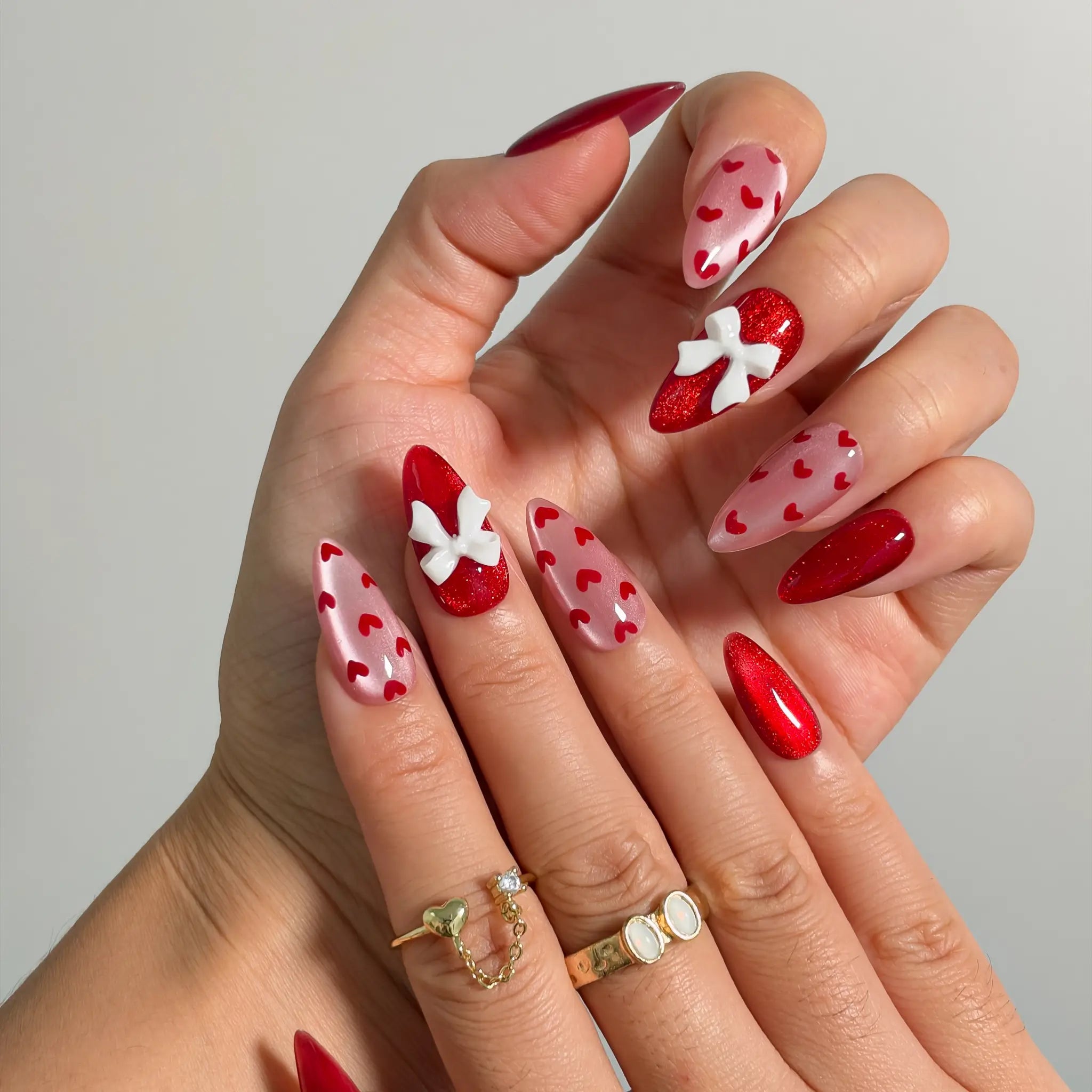 Crimson Heart Parade Long Almond press-on nails, modeled detail view 1
