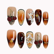 Amber Botanical Heirloom press-on nails in Brown, Orange, Gold on a white background