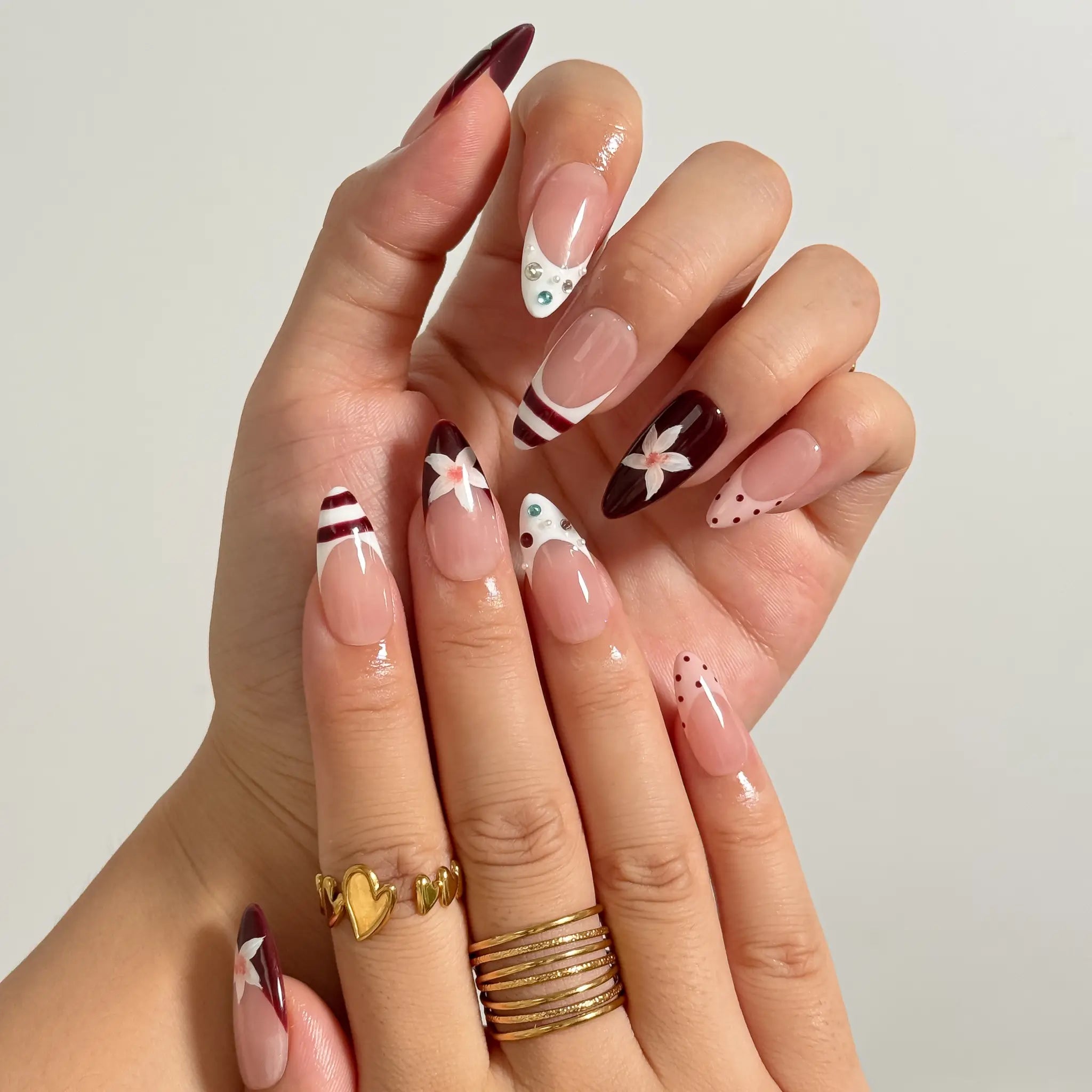 Burgundy Bow Sonata medium almond press-on nails worn on hands, view 2