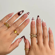 Burgundy Bow Sonata medium almond press-on nails worn on hands, view 3