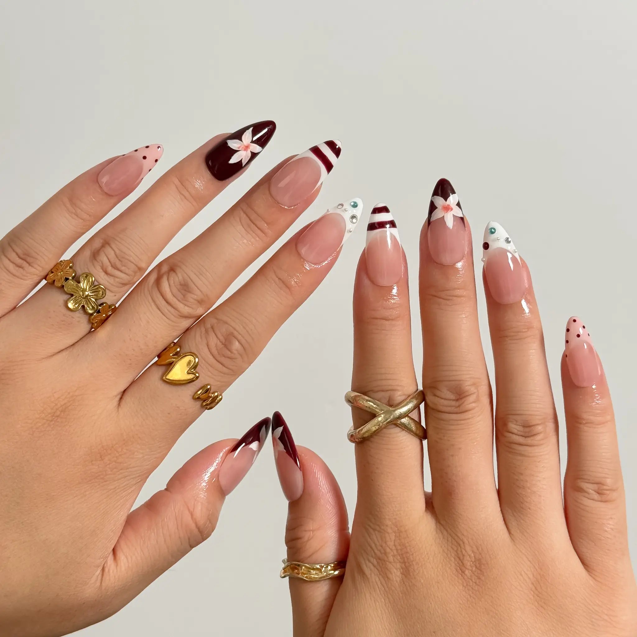 Burgundy Bow Sonata medium almond press-on nails worn on hands, view 3