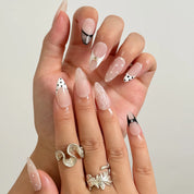 Noir Lace Whisper long almond press-on nails worn on hands, view 2