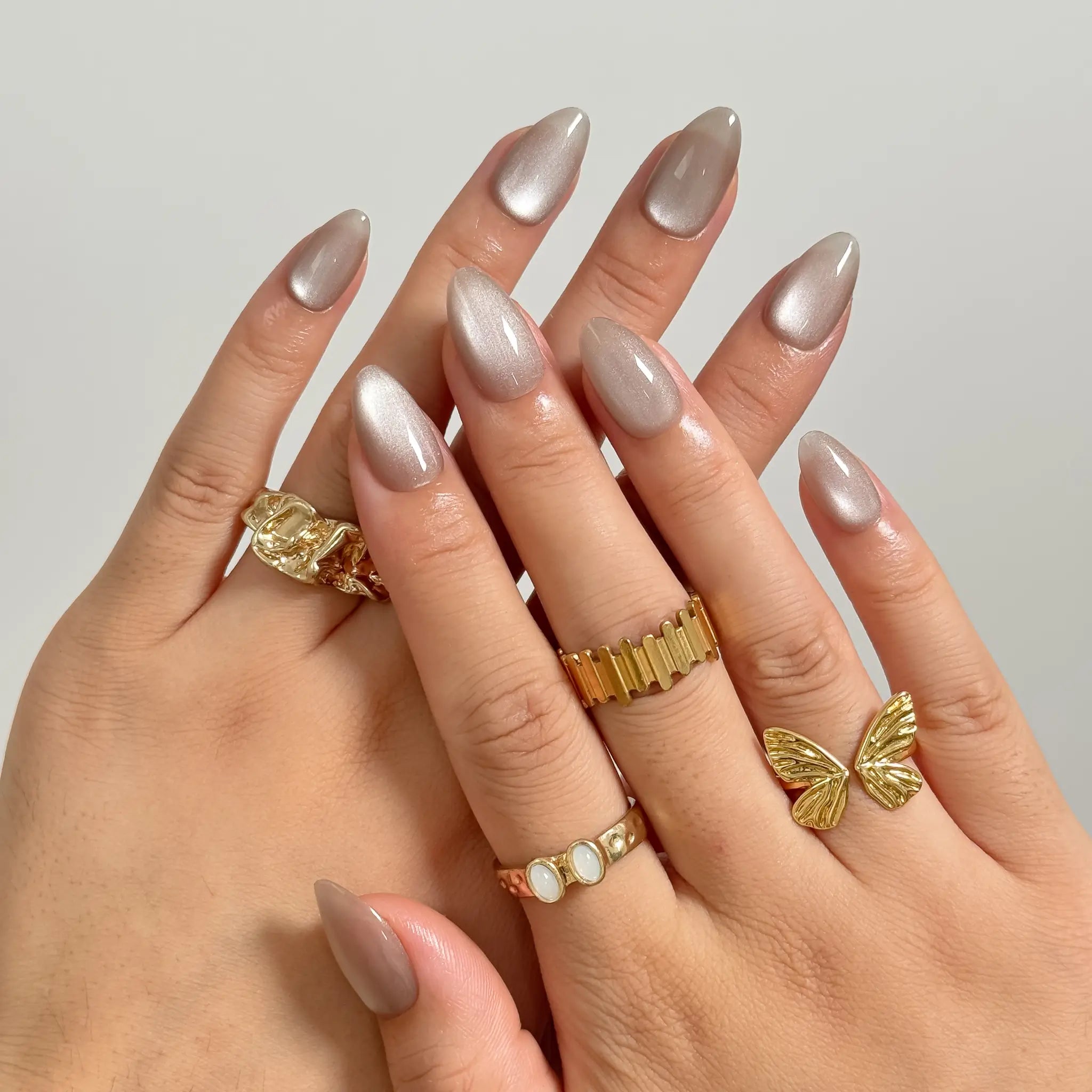 Silver Taupe Halo medium almond press-on nails worn on hands, view 1