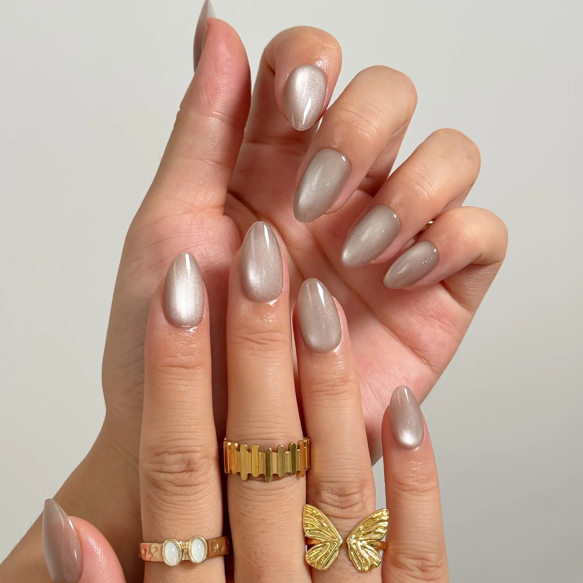 Silver Taupe Halo medium almond press-on nails worn on hands, view 2