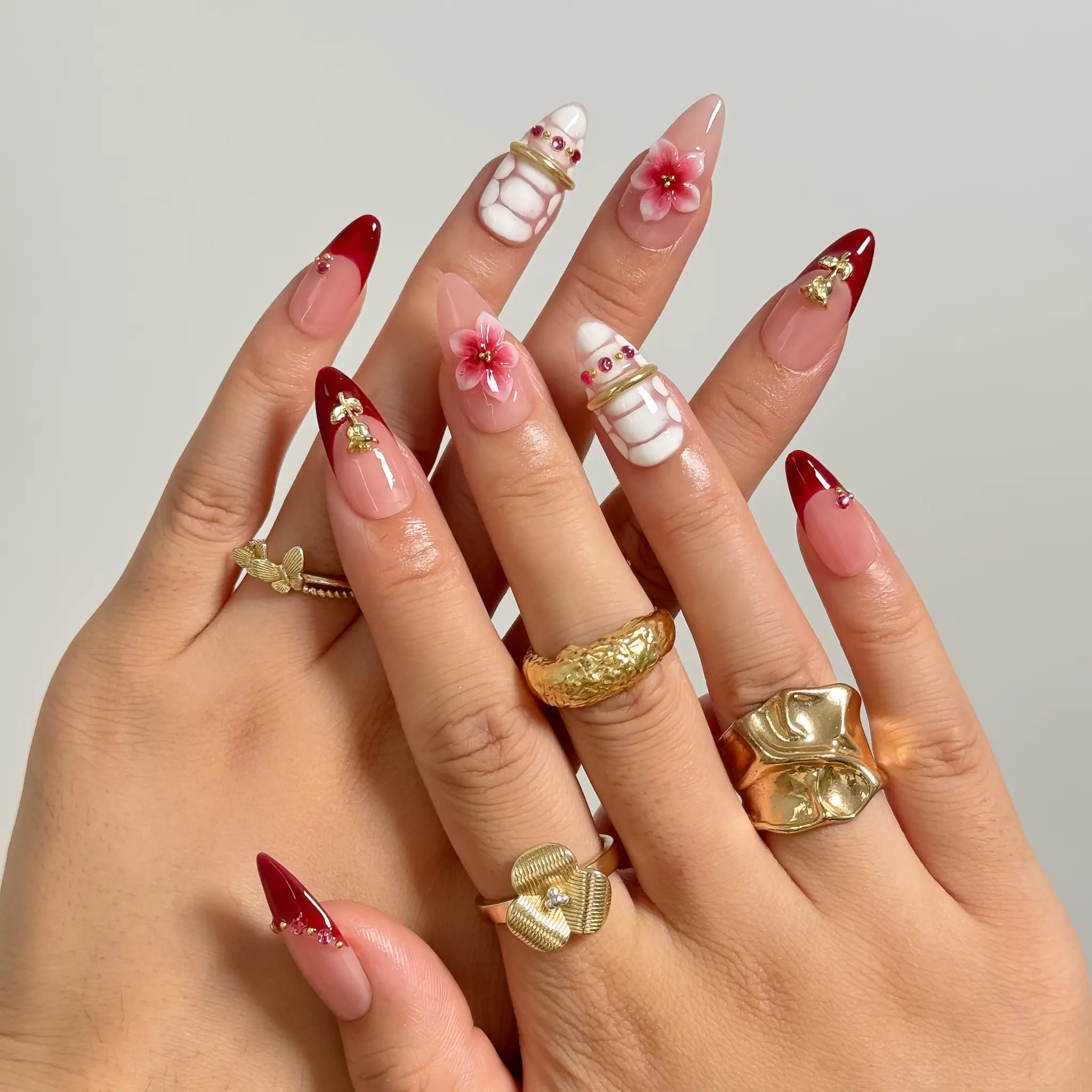 Crimson Garden Jewel medium almond press-on nails worn on hands, view 1