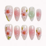 Jade Blossom Veil press-on nails in pink, white, and soft green with 3D flowers, pearl details, glitter, and a jade-inspired charm