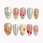 Orchard Stripe Daydream press-on nails in nude, cream, blue, yellow, red, and green with fruit motifs, stripes, and floral details