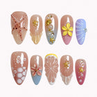 Seashell Garden Reverie press-on nails in pink, blue, coral, yellow, and nude with shells, flowers, starfish, pearls, and 3D details