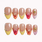 Sunlit Hibiscus Tide press-on nails in nude, yellow, orange, pink, and gold with flowers, starfish, pearls, and shell details